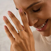 Woman model wearing a 14k gold filled ring with colored gemstones on a neutral background